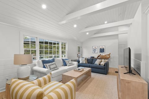Living room with a couch, queen size sleeper sofa, comfy chair, coffee table, and tv