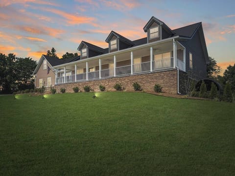 This welcoming home stretches wide beneath stunning sunset skies. With a long, classic front porch and plenty of green space, you’ll feel like you’ve stepped into your own slice of quiet authentic country living.