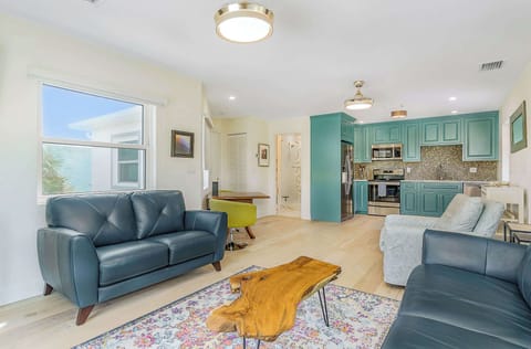 Open living area with teal kitchen cabinets and natural wood accents for a modern feel.