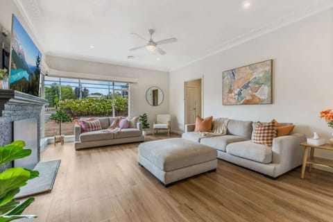 Expansive living room with beautiful light, flat screen TV and ample seating.