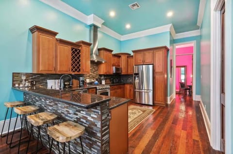 Spacious kitchen featuring a full set of appliances, bar seating at the counter, and all the cookware, dishes, and utensils you could need.