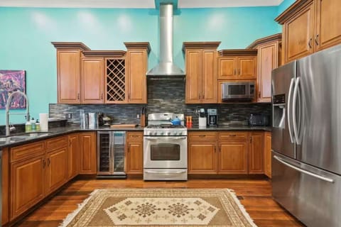 Another view of the chef-friendly kitchen featuring a full-size fridge, gas range, and plenty of counter space for meal prep.