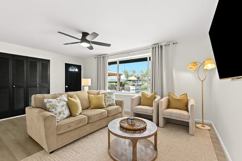 Bright and welcoming, this living area features a large window, comfy seating, and charming pillows for the perfect home-away-from-home vibe.