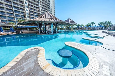 Dive into relaxation at this stunning resort style pool with swim-up seating.