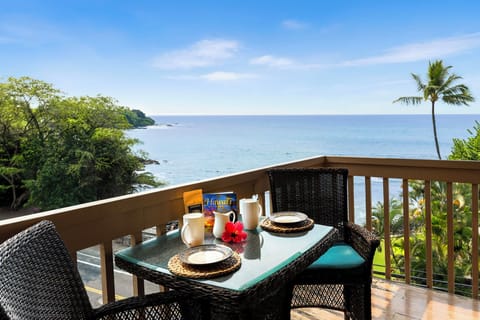 Oceanfront breakfast on a private balcony with seating for two, offering stunning water views.