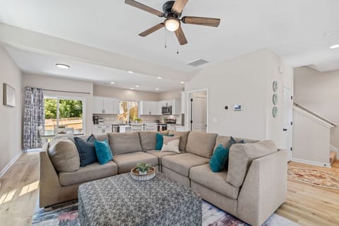 Large living room in the open concept living space downstairs. Includes a large sofa and 65` smart TV.