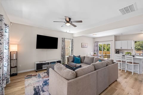 Large living room in the open concept living space downstairs. Includes a large sofa and 65` smart TV.