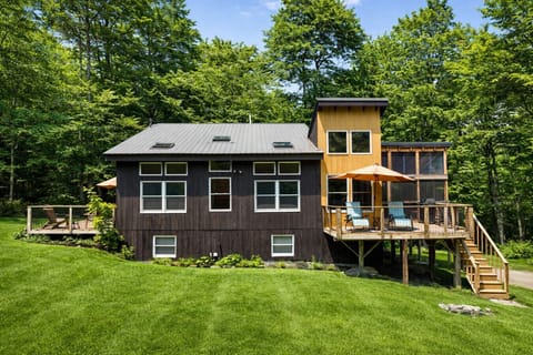 Modern cabin retreat with a spacious deck, outdoor seating, and peaceful forest surroundings.