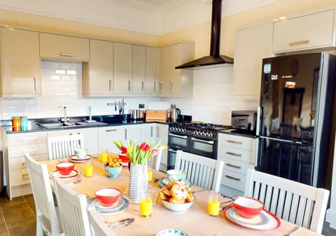 A fully equipped modern kitchen with a dining area, ideal for preparing meals and enjoying family time.