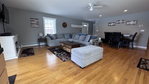 Living room with sizeable L-shaped couch with open concept to kitchen and dining area