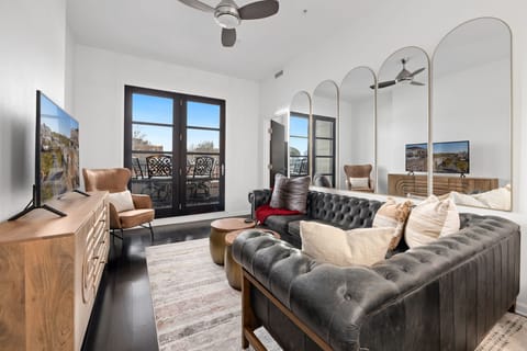 Inside, there is fully stocked kitchen with bar seating and a living room featuring a couch a large Smart TV.
