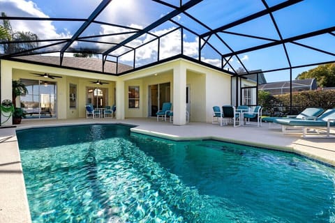 Spacious pool deck with a covered lanai, lounge chairs and outdoor dining—perfect for relaxing or entertaining.