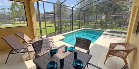 Enjoy open-air meals in this cozy, covered dining space overlooking the sparkling pool.