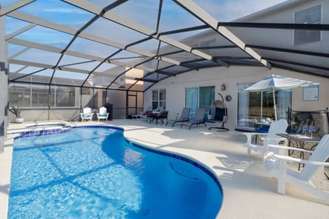 Enjoy sunny days in this private outdoor oasis. The screened-in pool and relaxing spa provide a perfect retreat for both adults and kids, complete with loungers and shaded seating.