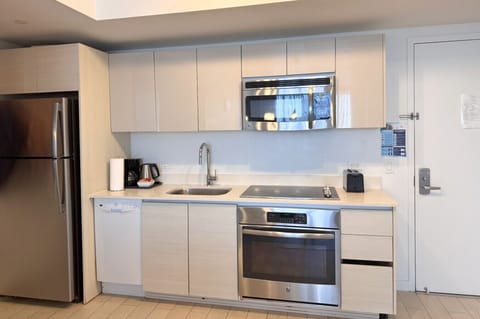 Fully equipped kitchen with stainless steel appliances and a stylish backsplash.