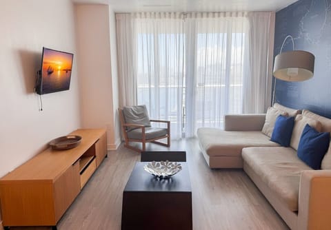 Bright living room with balcony access and city views.