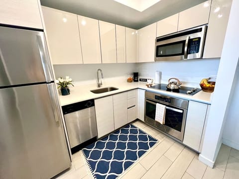 Fully equipped kitchen with stainless steel appliances and a stylish backsplash.