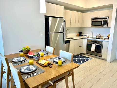 Fully equipped kitchen with stainless steel appliances and a stylish backsplash.
