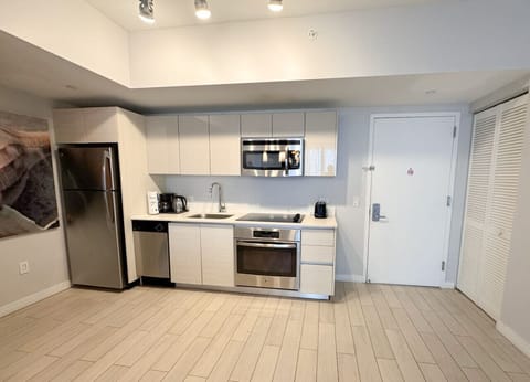 Fully equipped kitchen with stainless steel appliances and a stylish backsplash.