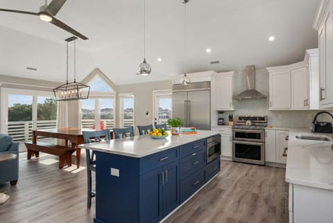 Open-concept kitchen with high-end finishes, a farmhouse-style dining area, and stylish lighting.