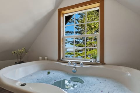 Soaking tub with tranquil forest and water views, your private spa.