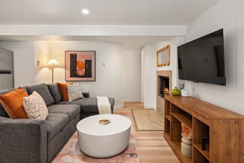 Your open-concept living/dining/kitchen area with Smart TV, full-sized fold out couch, and wood-burning fireplace.