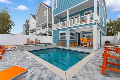 Dive into your own private pool surrounded by vibrant orange lounge chairs and turquoise coastal charm.