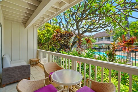 Sip your morning coffee on your private balcony overlooking tropical gardens and the sparkling pool, surrounded by lush greenery and vibrant island blooms.
