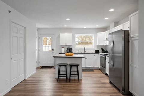 Kitchen fully equipped with island seating, Door to access backyard.