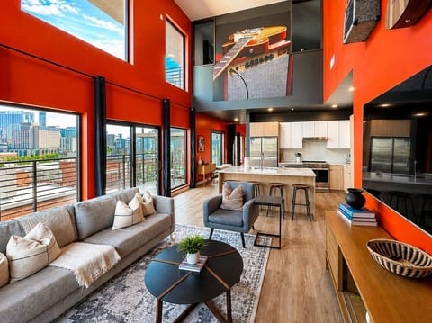 Open concept living/dining/kitchen with vaulted penthouse ceilings