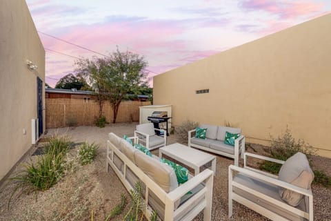 Private, fully fenced backyard with cozy seating and gas grill