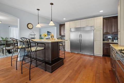 Your spacious kitchen features gleaming hardwood floors, stainless steel appliances, and a large island perfect for morning coffee or casual meals.