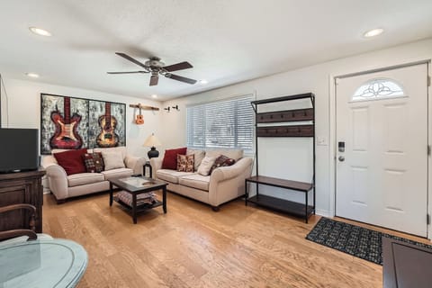 Unwind in your spacious living room featuring plush seating, music-themed artwork, and a convenient Murphy bed for extra guests.