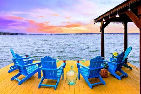 The boat dock features stunning sunset views over the water, complete with comfortable Adirondack chairs for the perfect lakeside retreat.