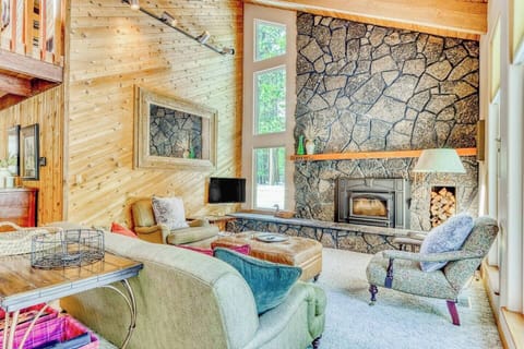Warm living room with stone fireplace and comfortable seating—perfect for relaxing and entertaining.
