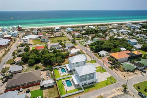 Coastal beachfront community with turquoise waters and white sand beaches just steps away from residential neighborhoods.