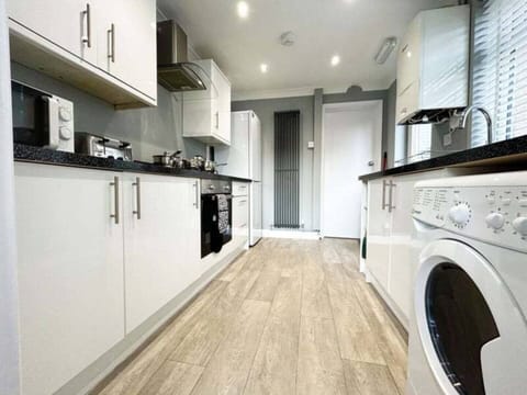 Fully equipped modern kitchen with appliances, cookware, and a washing machine for a convenient stay.