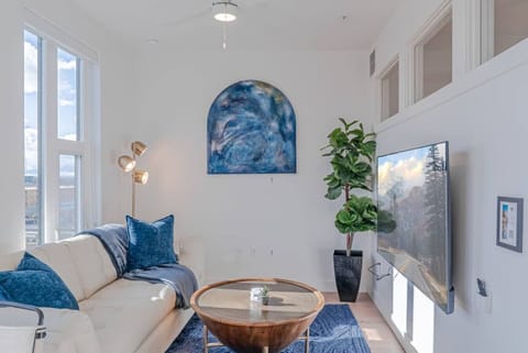 Beautifully designed living room. 65` TV, comfy sofa and amazing views of mountains and city skyline.