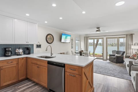 Your spacious waterfront retreat features a sleek modern kitchen flowing into a comfortable living area with stunning lake views right outside your door.