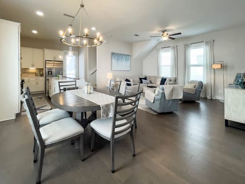 Modern open-concept living with marble counters, spacious dining, bar seating, and a comfy lounge with smart TV + soundbar.