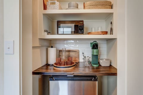 Kitchenette with mini fridge, coffee maker, glassware, flatware, and microwave