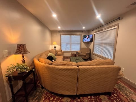 Living Room with a large sectional sofa, oversized ottoman and 43” TV.