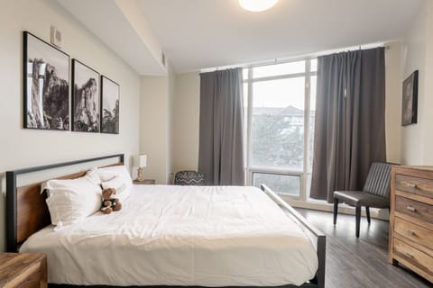 Wake up refreshed in this serene, sun-drenched bedroom. Featuring crisp white hotel-quality linens, calming landscape art, and beautiful floor-to-ceiling windows. Draw the heavy drapes when you want to sleep in, or open them wide to let the natural light 