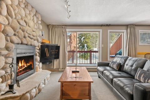 Living room with a (decorative) fireplace, comfortable seating, a TV with Shaw cable & access to the private balcony.