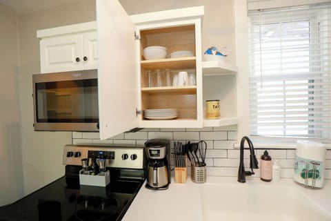 Kitchen showing inside of the cabinet where plates, cups and bowls are located.