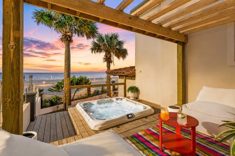 Private covered hot tub with partial Gulf views, comfortable outdoor seating, and a shaded pergola. Relax in a coastal retreat while enjoying ocean breezes and a peaceful beachfront atmosphere.