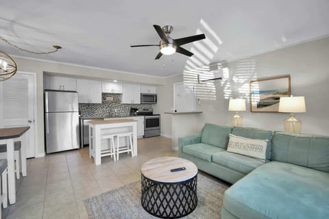 A bright and airy living space featuring a comfortable mint-green sectional sofa.