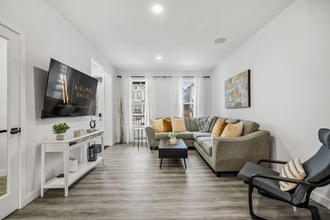 Main floor living room with a 65` smart TV and cozy seating options.