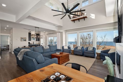 Open living space w/ plush sofas, vaulted ceilings, & sunlit windows made for relaxed coastal gatherings