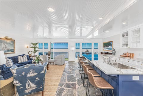 Bright open-concept living and kitchen area with ocean views and coastal-inspired décor
                